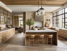 a large kitchen with lots of counter space and stools next to the center island