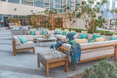 an outdoor seating area with couches, tables and chairs in front of a building