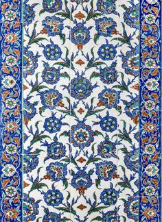 an intricately designed rug with blue and orange flowers on it's border,