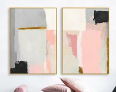 two paintings hanging on the wall above a bed with pink pillows and throw pillows in front of them