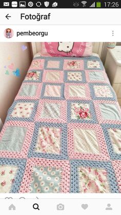 a crocheted bed with pink, blue and white bedspread on it