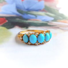 Found is this antique Victorian 20k yellow gold band ring handmade with five oval turquoise cabochons in graduating size with ten old European cut daimonds. The turquoise is natural bright blue and range in size from 6 x 5 x 3.28mm to 5.3 x 4.3 x 2mm. They are set in shared prongs side by side with two diamonds between each top and bottom and one at each end for a total of ten around .29cts., H-I Color, VS2-SI1 Clarity. The shank measures 1.64 mm wide by 1.00 mm thick at the bottom and 3.23 mm a Band With Diamonds, Old Mine Cut Diamond, Antique Engagement, Gold Band Ring, Antique Engagement Rings, Multi Stone Ring, Multi Stone, Gold Band, Ring Handmade