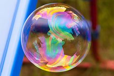 a soap bubble floating on top of a blue pole