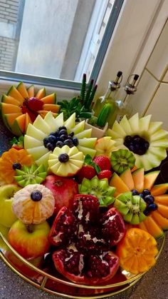 there are many different fruits arranged in the shape of animals on this table with spoons