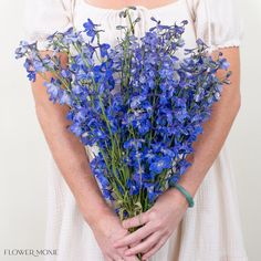 a woman holding a bouquet of blue flowers