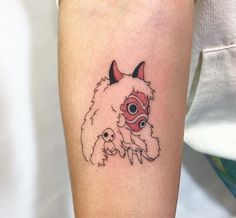 a small tattoo on the arm of a person with a dog and cat face in it