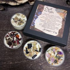 four small bowls filled with different types of flowers and herbs in front of a box