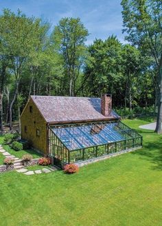 this is an aerial view of a house with a large glass greenhouse in the front yard