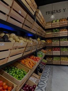 the produce section of a grocery store with fresh fruits and vegetables in wooden crates on shelves