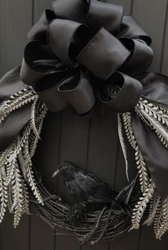 a black wreath with silver leaves and a bird on it