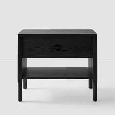 the side table is made from black wood and has an open drawer on one side