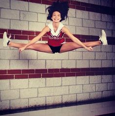 a woman is jumping in the air with her legs spread out and one leg up