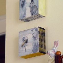 three paintings hang on the wall next to a teddy bear