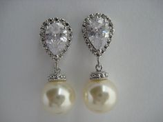 Classic cubic zirconia and pearl bridal earrings in rhodium plated brass setting. Earrings feature clear cubic zirconia teardrop ear post and a 10mm Swarovski cream pearl dangle drop. Total length of the earrings is 2.7 cms.For matching necklace click:https://www.etsy.com/listing/252977878/cream-pearl-and-crystal-bridal-necklace?ref=shop_home_active_10For matching bracelet click:https://www.etsy.com/listing/253699301/classic-bridal-cream-pearl-bracelet?ref=shop_home_active_5 To browse my collect Silver Pear-shaped Bridal Earrings For Anniversary, Silver Pear-shaped Cubic Zirconia Bridal Earrings, White Gold Cubic Zirconia Pearl Earrings For Wedding, Classic Silver Pearl Earrings For Wedding, Silver Classic Pearl Earrings For Wedding, Classic Pearl Earrings With Cubic Zirconia For Wedding, Classic Cubic Zirconia Pearl Earrings For Wedding, Pearl Bridesmaid Jewelry, Engagement Look