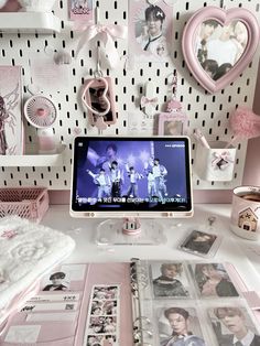 a desktop computer sitting on top of a desk next to pictures and other items in front of a wall