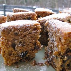 several pieces of cake sitting on top of a white plate covered in powdered sugar