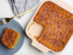 a casserole on a plate with a fork next to it and a piece of cake