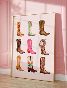 a framed photo with cowboy boots on it in front of a pink wall and wooden floor