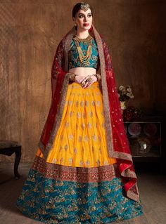 Make a statement in this beautiful lehenga set featuring a green silk embroidered blouse, yellow silk A-line lehenga with embroidery, and a red net embroidered dupatta. The contrasting yet complementary colors and intricate embroidered details make this a showstopping ethnic ensemble perfect for weddings and festivals. #yellowlehenga #yellowlehengas #yellowlehengacholi #yellowlehengadress #yellowlehengadesigns #yellowcolorlehenga Indian Wedding Guest Dress, Pink Sharara, Dori Embroidery, Blue Dupatta, Lehenga Choli Wedding, Wedding Dress Outfit