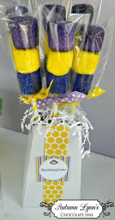 purple and yellow cake pops are wrapped in cellophane