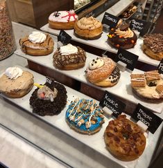 a display case filled with lots of different types of doughnuts and pastries