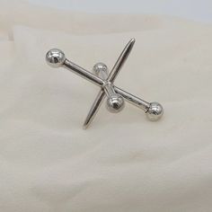 a pair of silver screws sitting on top of a white cloth