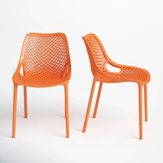 two orange plastic chairs sitting next to each other