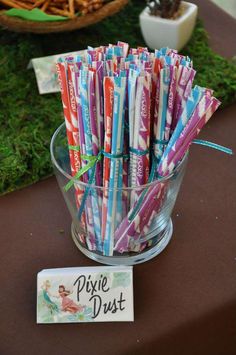 there are many toothbrushes in a glass cup on the table next to a sign