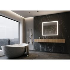 a bathroom with a large mirror above the bathtub and lights on the wall next to it