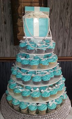 a tiered cake with blue cupcakes on it