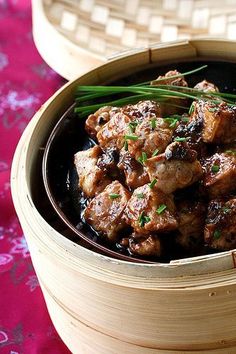 a close up of a bowl of food with meat and garnishes on it