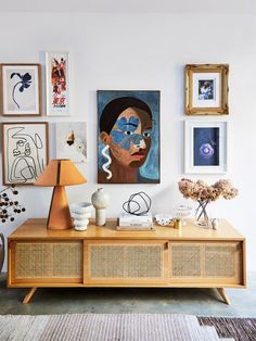 a living room with pictures on the wall and a wooden table in front of it