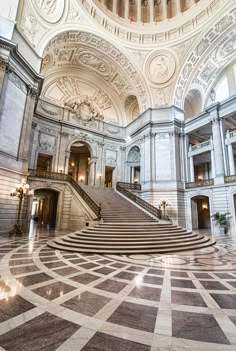 the inside of a large building with stairs and chandeliers on either side of it