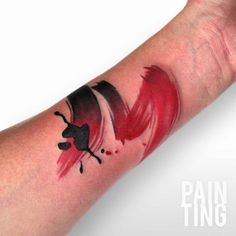 a red and black tattoo on the arm