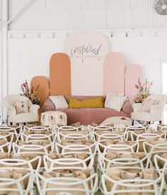 chairs and couches are lined up in front of a wall with the words inspired on it