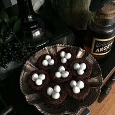 there are chocolate cookies and marshmallows on the plate next to an empty bottle