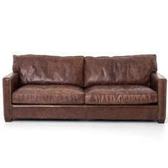 a brown leather couch sitting on top of a white floor