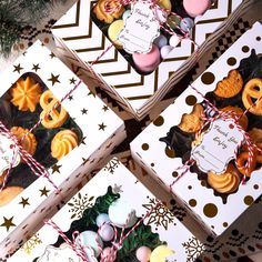 four christmas cookies are wrapped in paper and tied with twine