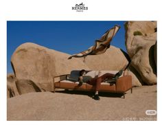 a man laying on top of a couch in the desert