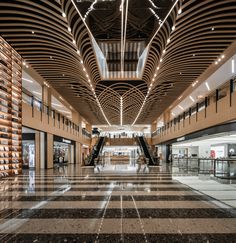 the inside of a large building with marble flooring and lights hanging from the ceiling