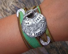 a close up of a person's arm wearing bracelets with an elephant on it