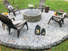 an outdoor fire pit surrounded by chairs and lanterns in the middle of a lawn area