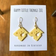 a pair of cheese shaped earrings sitting on top of a card