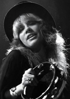 a black and white photo of a woman wearing a hat