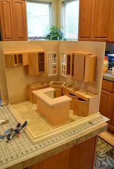 an unfinished kitchen with wooden cabinets and tools on the counter