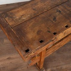 an old wooden bench sitting on top of a hard wood floor