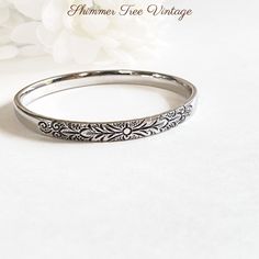 Elegant Whiting and Davis Co signed silver tone floral etched bangle.  This lovely and simple single bangle is etched on the front with a pretty etched flower and leaf motif.  The bracelet measures 2 5/8 inches in diameter X 5/16 inch width.   The bracelet is in great condition, nice and bright, not perfectly round but more oval in shape. Please be sure to look closely at all pictures as I do try to capture the items condition so that you may see any marks or flaws and make an informed decision. Silver Wedding Bracelets With Engraving Option, Elegant Stamped Bangle For Anniversary, Silver Bracelets With Engraving Option For Wedding, Vintage Silver Bracelets Hand Stamped, Elegant Silver Bangle With Engraving Option, Etched Bangle For Wedding, Vintage Silver Stackable Bangle, Single Bangle, Leaf Motif