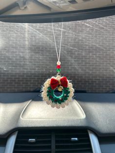 an ornament hanging from the dashboard of a car with a christmas wreath on it