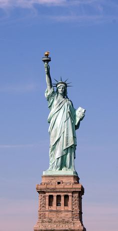 the statue of liberty in new york city, ny is shown against a blue sky