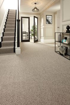 a carpeted entryway with stairs leading up to the second floor